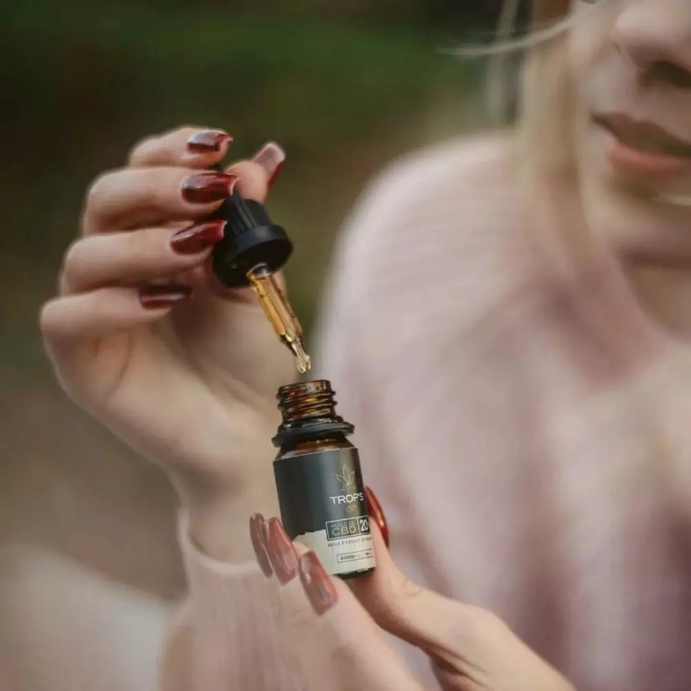 Présentation d'une huile de CBD par une femme